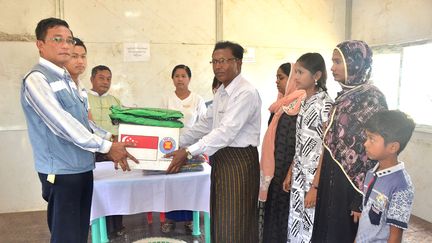 Une famille rohingya est accueillie par des responsables birmans à Maungdaw, près de la frontière avec le Bangladesh, le 14 avril 2018. (AFP PHOTO / MYANMAR NEWS AGENCY)