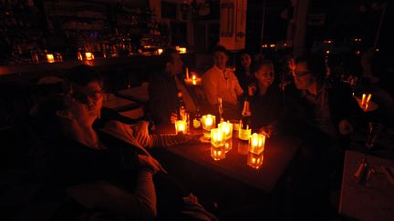 Clients et serveurs veillent &agrave; la bougie dans un restaurant de Greenwich village, &agrave; New York, pendant le passage de l'ouragan Sandy, le 30 octobre 2012. (BRENDAN MCDERMID / REUTERS)