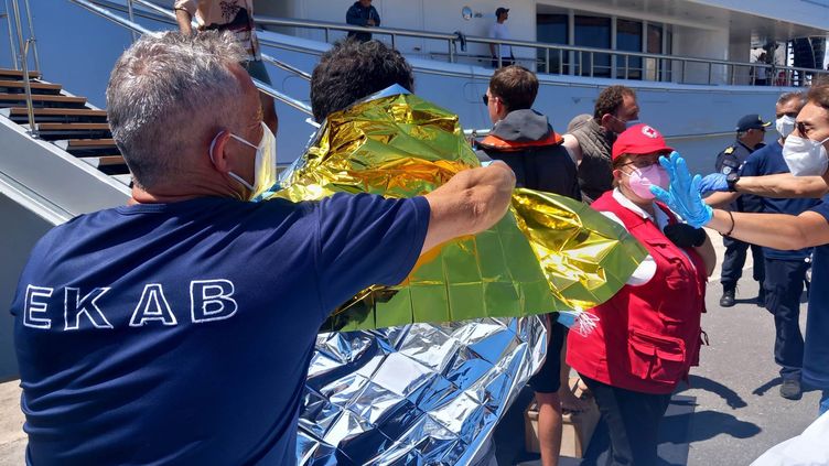 Des paramédicaux du Service national grec d'ambulance d'urgence (EKAV) et des membres de la Croix-Rouge grecque aident les migrants à leur arrivée au port de Kalamata, en Grèce, le 14 juin 2023. (BOUGIOTIS EVANGELOS / ANA-MPA / MAXPPP)