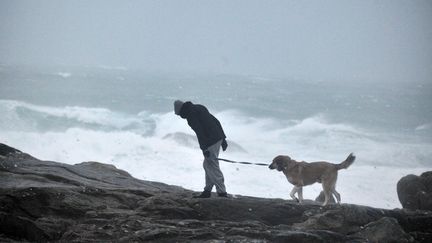 Un homme promène son chien à Saint-Guénolé, dans le Finistère, le 23 décembre 2013.&nbsp; (FRANK PERRY / AFP)