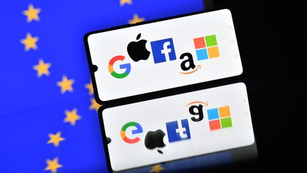 Un téléphone avec les logos de&nbsp;Google, Apple, Facebook, Amazon and Microsoft.&nbsp; (JUSTIN TALLIS / AFP)