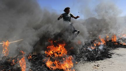 ... mais aussi des salari&eacute;s paup&eacute;ris&eacute;s, comme ce membre du Mouvement des travailleurs sans-abri, qui manifeste devant le stade national &agrave; Brasilia, le 14 juin 2013. (UESLEI MARCELINO / REUTERS)