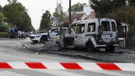 Le véhicule de police et une autre voiture, incendiés, à Viry-Châtillon (Essonne), le 8 octobre 2016. (THOMAS SAMSON / AFP)