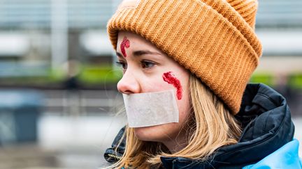 Une manifestante s'est baillonnée pour protester contre la guerre en Ukraine, devant le Conseil européen à Bruxelles, le 6 avril 2022. (JONAS ROOSENS / MAXPPP)