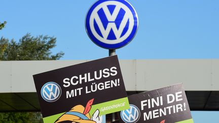 Des activistes tiennent des pancartes "Arr&ecirc;tez de mentir" pour protester contre le scandale Volkswagen, le 25 septembre 2015 &agrave; Wolfsburg, en Allemagne.&nbsp; (JOHN MACDOUGALL / AFP)