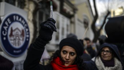 Une femme tient un stylo pendant la minute de silence observ&eacute;e &agrave; Istanbul (Turquie). (BULENT KILIC / AFP)