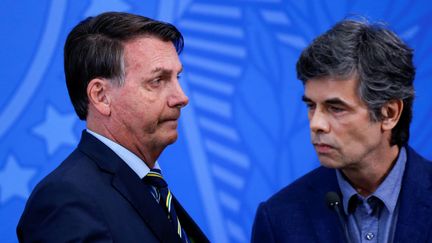 
Le président brésilien, Jair Bolsonaro, aux côtés de son ministre de la Santé, Luiz Henrique Mandetta, le 16 avril 2020, à Brazilia. (ADRIANO MACHADO / REUTERS)