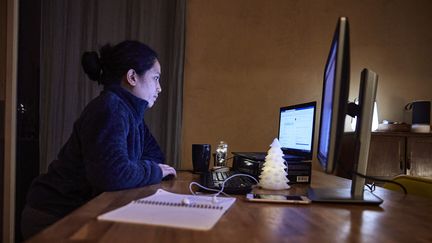 Une femme télétravaille dans son salon, le 13 décembre 2020 à Montaigu (Vendée). (MATHIEU THOMASSET / HANS LUCAS / AFP)