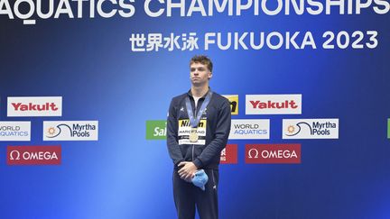 Le Français Léon Marchand, lors de la "Marseillaise", après son deuxième titre mondiale à Fukuoka (Japon), sur 200 m papillon, le 26 juillet 2023. (KEMPINAIRE STEPHANE / KMSP)