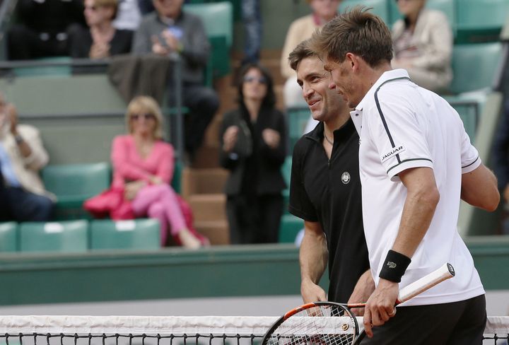 Gilles Simon et Nicolas Mahut, tout sourire, se&nbsp;retrouvent au filet à la fin du&nbsp;troisième tour de Roland-Garros, le 29 mai 2015. (PATRICK KOVARIK / AFP)