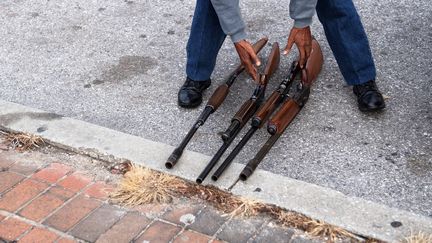 Un homme montre quatre fusils à pompe destinés à être vendus à Baltimore (Maryland), le 17 décembre 2018. (JIM WATSON / AFP)