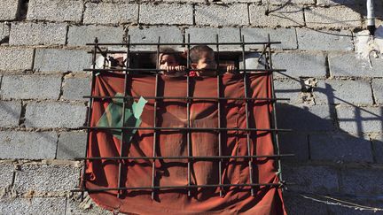 Des enfants regardent par la "fen&ecirc;tre" de leur domicile dans la banlieue d'Alger (Alg&eacute;rie), le 8 mai 2012. (ZOHRA BENSEMRA / REUTERS)