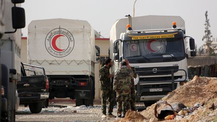 Des camions&nbsp;du&nbsp;Comité international de la Croix-Rouge stationnent à un checkpoint aux limites de la Ghouta orientale, en Syrie, le 8 mars 2018. (AFP)