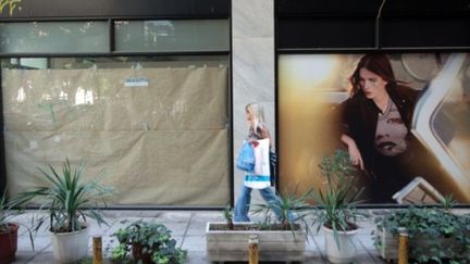 Une femme marche devant un magasin fermé, à Thessalonike, le 9 septembre 2011 (AFP/SAKIS MITROLIDIS)