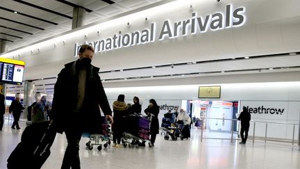 Des passagers à l'aéroport d'Heathrow,&nbsp;près de Londres (Royaume-Uni), le 28 novembre 2021. (HASAN ESEN / ANADOLU AGENCY / AFP)