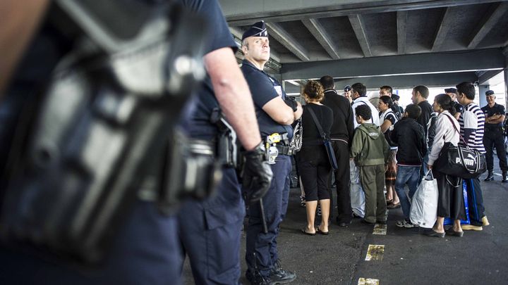 Des policiers proc&egrave;dent &agrave; des contr&ocirc;les d'identit&eacute; pendant l'&eacute;vacuation de 80 Roms dans un camp de Lyon (Rh&ocirc;ne), le 9 juillet 2012. (ALEXANDRE ROTH-GRISARD / MAXPPP)