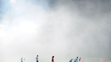 Les joueurs de Lyon et de l'Ajax sur le terrain du stade Gerland, et face au brouillard des fumig&egrave;nes, le 22 novembre 2011. (PHILIPPE MERLE / AFP )