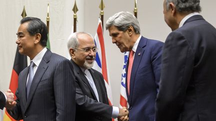 Le ministre des Affaires &eacute;trang&egrave;res iranien, Mohamad Javad Zarif, serrant la main de son homologue am&eacute;ricain John Kerry, le 24 novembre 2013 &agrave; Gen&egrave;ve (Suisse). (FABRICE COFFRINI / AFP)