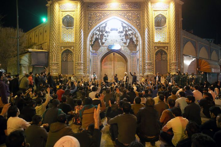 Des fidèles sont rassemblés devant les portes closes&nbsp;du sanctuaire de&nbsp;Fatima Massoumeh,&nbsp;à&nbsp;Qom, en Iran, le 16 mars 2020.&nbsp;Mi-mars, les autorités iraniennes ont annoncé la fermeture de quatre importants lieux saints, dont le sanctuaire de&nbsp;Machhad, première ville sainte chiite d'Iran, pour lutter contre le&nbsp;coronavirus.&nbsp; (MEHDI MARIZAD / AFP)