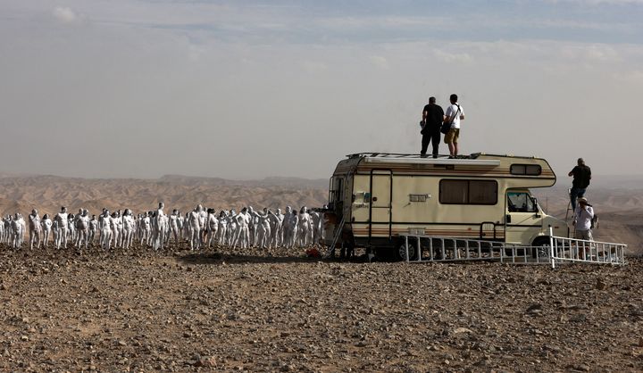 Le photographe américain Spencer Tunick donne des instructions à des centaines de personnes posant nues près de la Mer Morte en Israël, le 17 octobre 2021. (MENAHEM KAHANA / AFP)