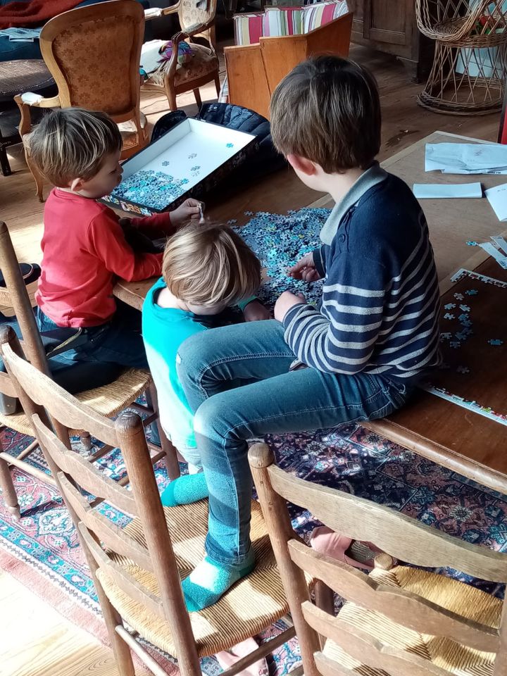 Trois des quatre enfants de Marie jouent au puzzle, le 20 mars 2020, dans leur maison de Gironde. (MARIE / FRANCEINFO)