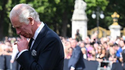 Le roi Charles III a&nbsp;pris le temps de se recueillir devant les fleurs déposées sur les grilles du palais royal, un jour après la mort de la reine Elizabeth II. (DANIEL LEAL / AFP)