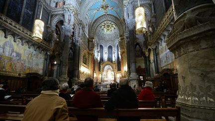 Des fidèles prient à Notre-Dame-de-Fourvière, le 5 mars 2013, à Lyon. (PHILIPPE DESMAZES / AFP)