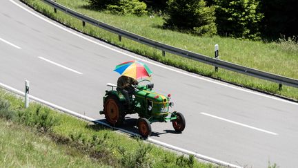 Un homme conduit son tracteur sur une route, le 11 juin 2017. (Photo d'illustration) (PATRICK SEEGER / DPA)