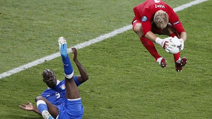 Le gardien anglais Joe Hart saute au-dessus de l'Italien Mario Balotelli (G) en quarts de finale de l'Euro &agrave; Kiev (Ukraine), le 24 juin 2012. (MICHAEL DALDER / REUTERS)