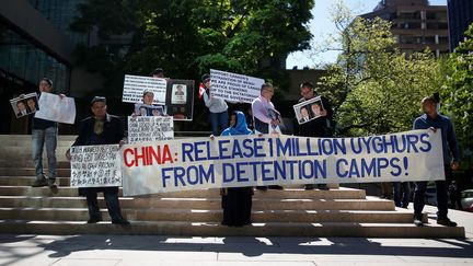 Des personnes brandissent des pancartes pour protester contre le traitement réservé&nbsp;aux Ouïghours par la Chine, à Vancouver (Canada), le 8 mai 2019.&nbsp; (LINDSEY WASSON / X06566)