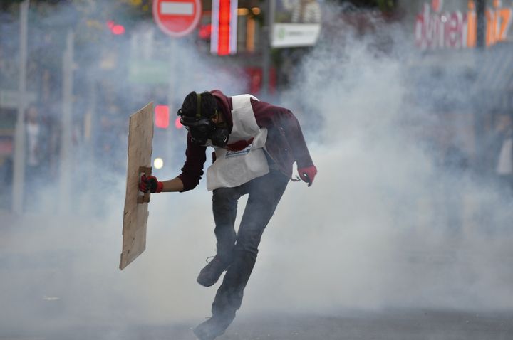 Un manifestant se prot&egrave;ge des gaz lacrymog&egrave;ne tir&eacute;s par les forces de l'ordre, &agrave; Ankara (Turquie), le 15 mai 2014.&nbsp; (REUTERS)