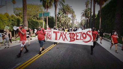 Une image de manifestation réclamant au patron d'Amazon Jeff Bezos de payer l'impôt, extraite du documentaire "La (très) Grande Evasion" de Yannick Kergoat (2022). (WILD BUNCH)