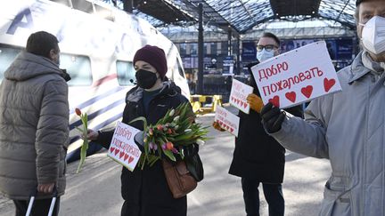 À la gare d'Helsinki, à la descente du train en provenance de Saint-Pétersbourg, les passagers sont accueillis par des pancartes de bienvenue.&nbsp; (EMMI KORHONEN / LEHTIKUVA/AFP)