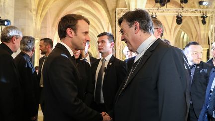 Emmanuel Macron avec l'archevêque de Paris, Michel Aupetit, le 10 avril. (LUDOVIC MARIN / AFP)