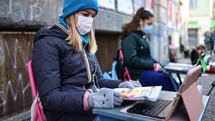 Anita Lacovelli (à gauche) refuse le reconfinement et s'est installée devant son collège à Turin (Italie). (MIGUEL MEDINA / AFP)