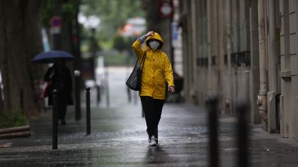 Une femme masquée en raison de la crise sanitaire, marche sous la pluie dans les rues de Paris en mai 2020. Photo d'illustration. (LP/ AURELIE AUDUREAU / MAXPPP)