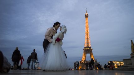 Un couple &eacute;gyptien s'embrasse devant la Tour Eiffel, le 29 octobre 2012 &agrave; Paris. (FRED DUFOUR / AFP)