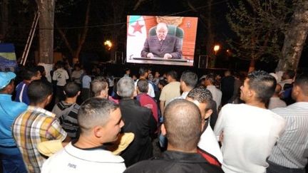 Des Algériens écoutent un discours du président Bouteflika le 15 avril 2011, retransmis sur écran géant à Tlemcen (AFP - FAROUK BATICHE )