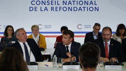 Emmanuel Macron, entouré de François Bayrou (à gauche),&nbsp;secrétaire général&nbsp;du Conseil national de la refondation, et du ministre de la&nbsp;Santé, François Braun, à Craon (Mayenne), le 10 octobre 2022.&nbsp; (LUDOVIC MARIN / AFP)