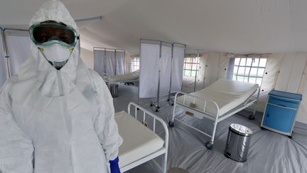 Un soignant &agrave; l'int&eacute;rieur d'une tente de traitement du virus Ebola, le 17 octobre 2014, &agrave; l'h&ocirc;pital universitaire de Yopougon (C&ocirc;te d'Ivoire). (SIA KAMBOU / AFP)