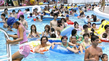 Des baigneurs dans une piscine, &agrave; Tokyo, au Japon, le 25 juillet 2004.&nbsp; (KAZUHIRO NOGI / AFP)