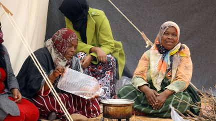 8 février 2018 : des femmes préparent le repas dans un camp de réfugiés, à 20 km de Tawergha, leur ville d'origine. (MAHMUD TURKIA / AFP)