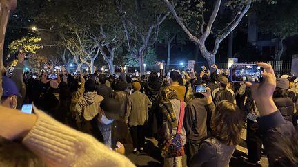 Des manifestants filment un rassemblement en la mémoire des victimes de l'incendie d'un immeuble à Urumqi, à Shanghai (Chine), le 27 novembre 2022.&nbsp; (MAXPPP)