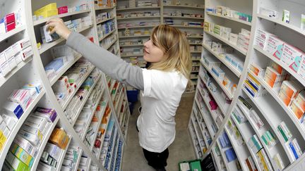 Une pr&eacute;paratrice en pharmacie devant les rayonnages de m&eacute;dicaments, le 11 d&eacute;cembre 2012. (MAXPPP)