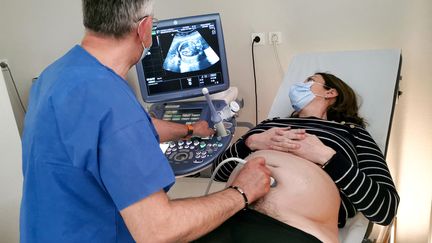 Un obstétricien-gynécologue réalise une échographie sur une femme enceinte, le 13 avril 2022. (NICOLAS GUYONNET / HANS LUCAS via AFP)