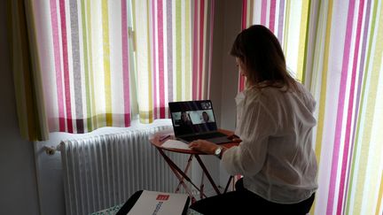 Une femme télétravaille à son domicile, le 15 mai 2020. (VALERY HACHE / AFP)