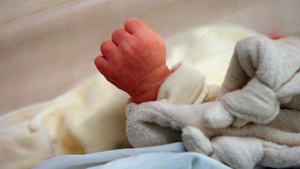 La main d'un nourrisson dans&nbsp;son berceau durant son sommeil, le 5 juin 2001, à&nbsp;l'hôpital franco-britannique de Levallois-Perret (Hauts-de-Seine). (DIDIER PALLAGES / AFP)