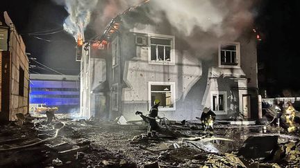 Des sauveteurs travaillent à côté d'un bâtiment administratif endommagé par une attaque de drone dans la région de Kiev (Ukraine), dans la nuit du 29 au 30 janvier 2024. (HANDOUT / UKRAINIAN EMERGENCY SERVICE / AFP)