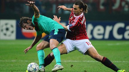 Zlatan Ibrahimovic à la lutte avec Carlos Puyol.  (OLIVIER MORIN / AFP)