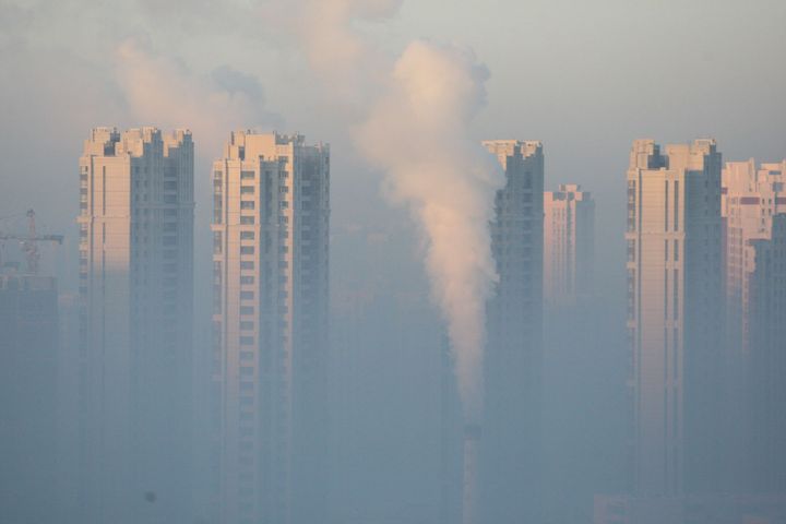 Sur cette photo, une cheminée devant des immeubles résidentiels à Harbin durant une journée polluée, dans le nord-est de la Chine, le 21 janvier 2016. (REUTERS / Stringer)